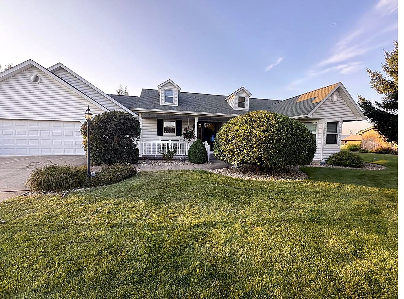 White home at dusk with trimmed shrubs