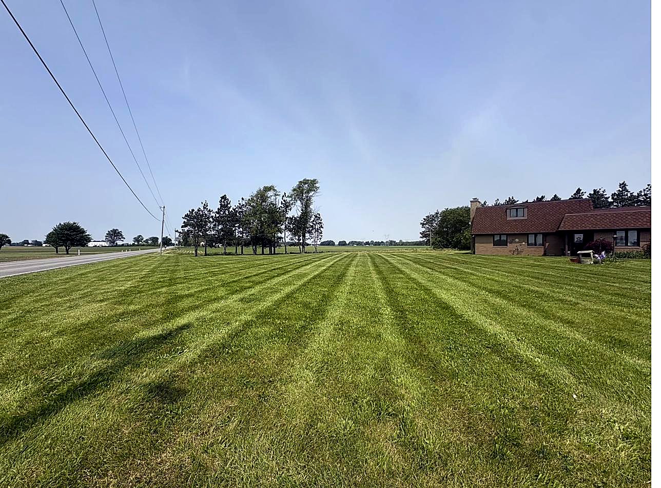 Crew truck and trailer at a freshly mowed property